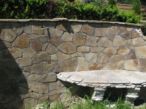Mur oporowy wykończony piaskowcem oraz ława z piaskowca